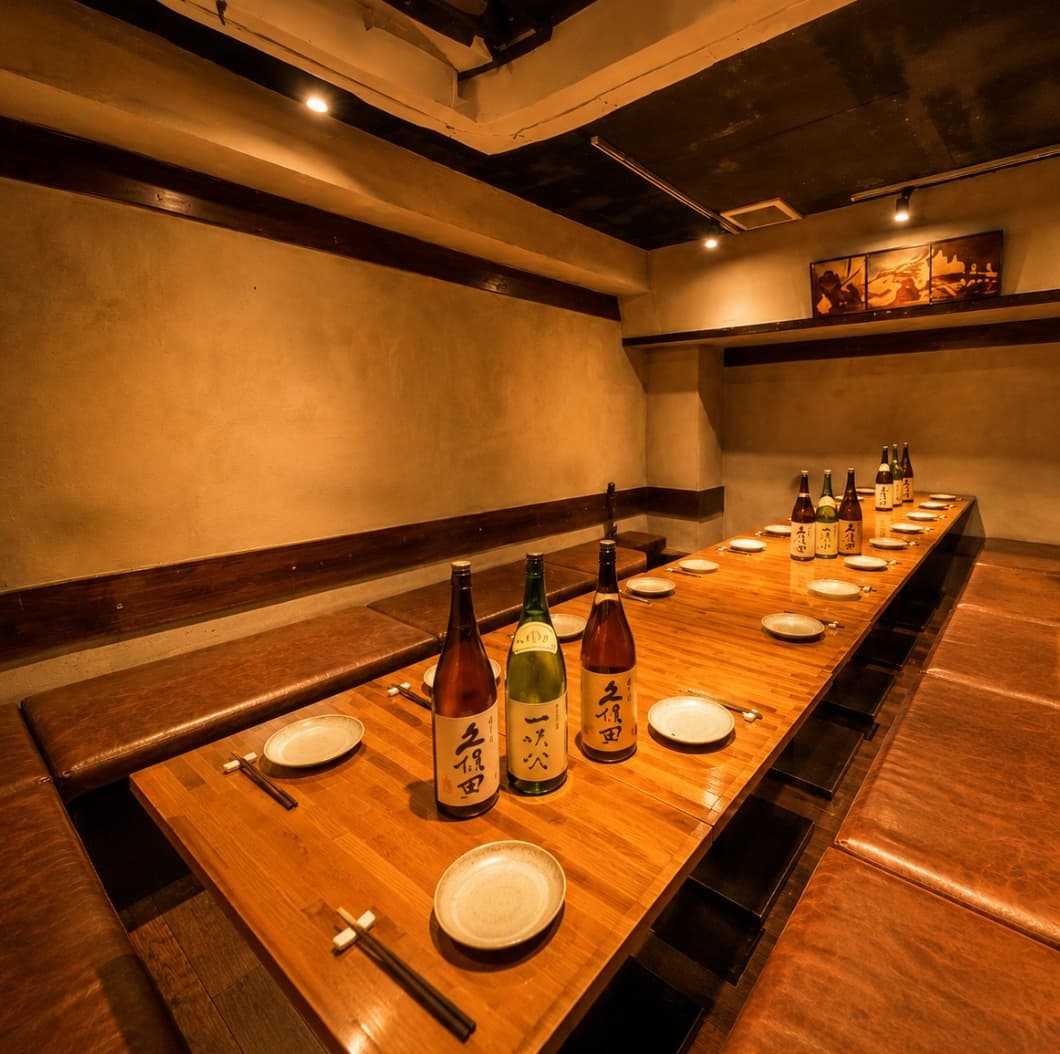 A long wooden dining table and bench seating at Torimonogatari Shibuya